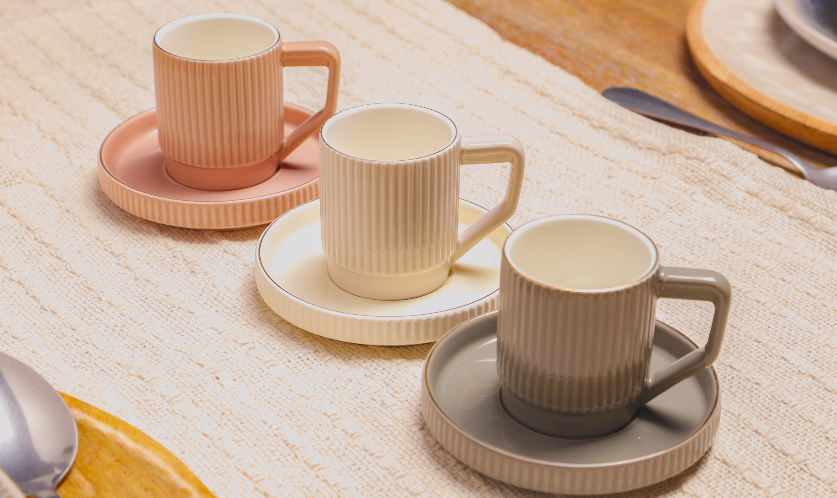 Ceramic coffee cups with saucers arranged on a dining table